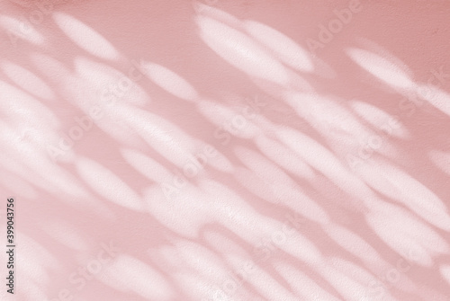 Abstract light shadow of leaves blurred background. Natural diagonal leaves tree branch pink rose gold shadows and sunlight dappled on white concrete wall texture for background wallpaper and design