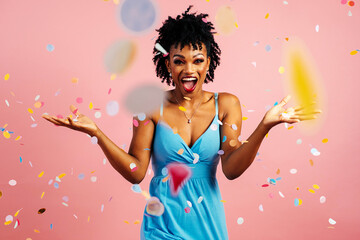 Portrait of a happy, excited young woman celebrating fun birthday or new year with colorful party confetti falling