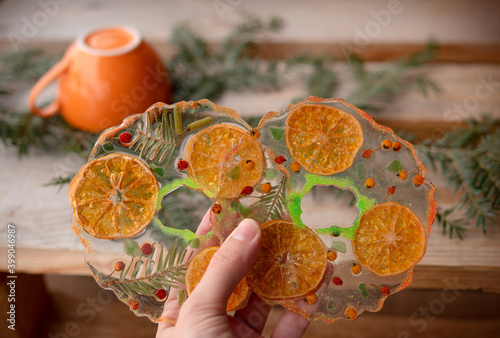 Handmade tea support from epoxy resin. Girl hand holder tea support with clementines, ideal for winter time
