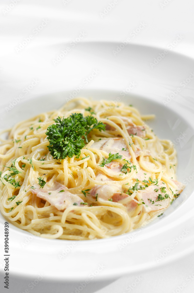 spaghetti carbonara pasta dish on white table background