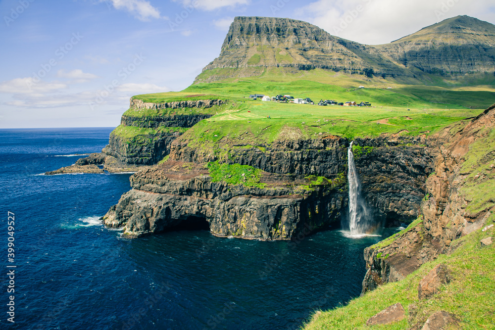 Faroes. Mulafossur waterfall in Gasadalur village in Faroe Islands, North Atlantic Ocean. Nordic Natural Landscape.