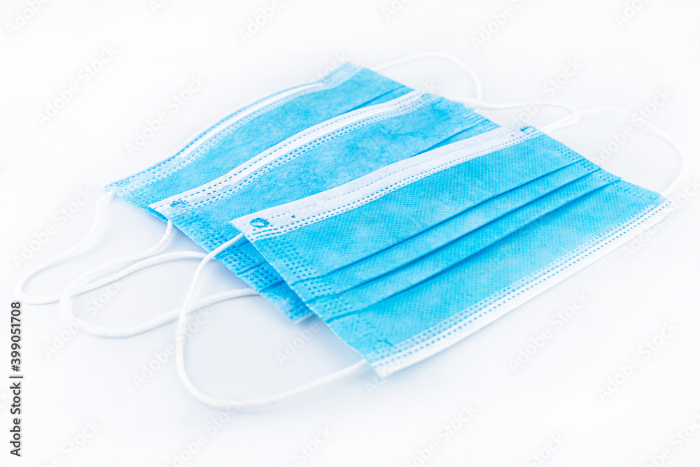 Fototapeta premium Three blue surgical masks for personal protection against the virus, isolated on a white background.