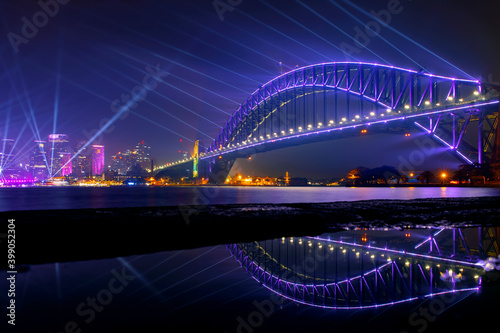 Sydney Harbour Bridge at night with beaming lights for Vivid Festival. View from Kirribilli puddle © Bostock