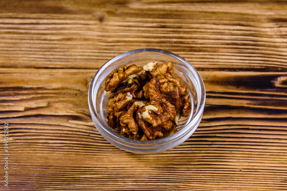 Cores of walnut in glass bowl on a wooden table Cores of walnut in glass bowl on a wooden table