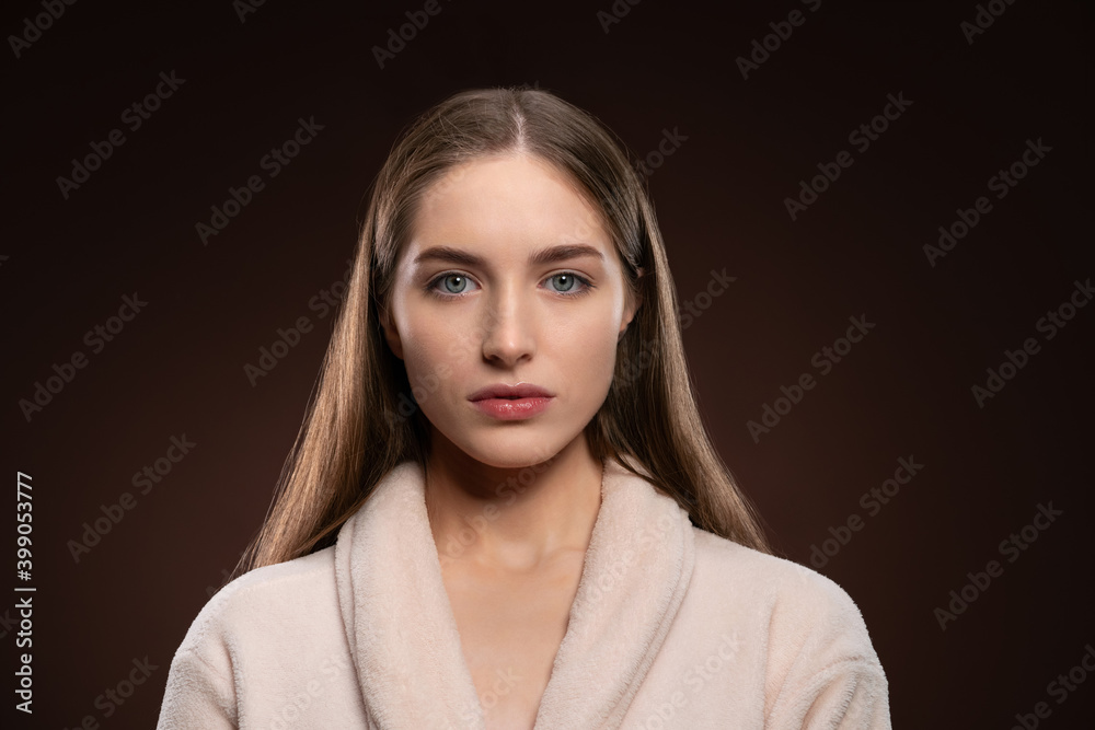 Standing in a bath robe natural beauty girl with no make up face. Healthy pure skin model posing on camera isolated on dark background. Natural make up concept. Spa and beautiful concept. Standing in a bath robe natural beauty girl with no make up face. Healthy pure skin model posing on camera isolated on dark background. Natural make up concept. Spa and beautiful concept.