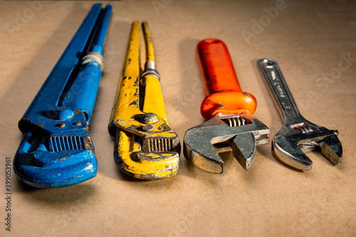 old adjustables wrenchs on wooden background. plumbing repair.