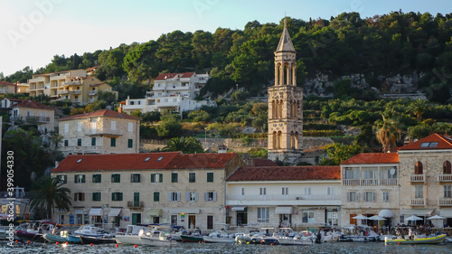 Panoramic view of Hvar town with boats docked in the harbor with the bell tower of Hvar Cathedral