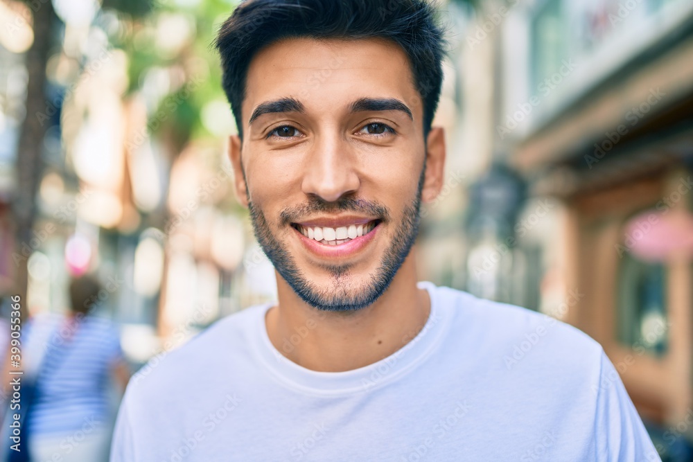 Young latin man smiling happy walking at the city. - obrazy, fototapety, plakaty 