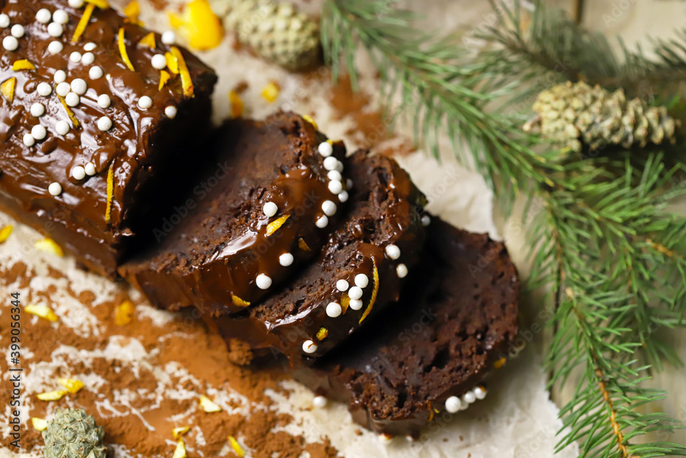 Chocolate cake with chocolate and orange. Christmas tree branches and cones. Christmas log. Festive sweets.