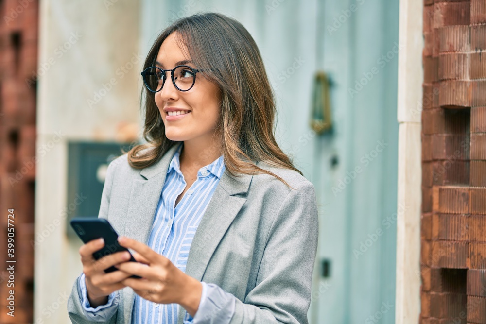 Young hispanic businesswoman smiling happy using smartphone at the city. Young hispanic businesswoman smiling happy using smartphone at the city.