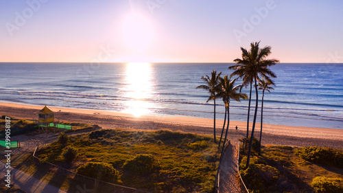 Aerial view over Gold Coast Main beach and ocean with palm trees and sunrise light. photo