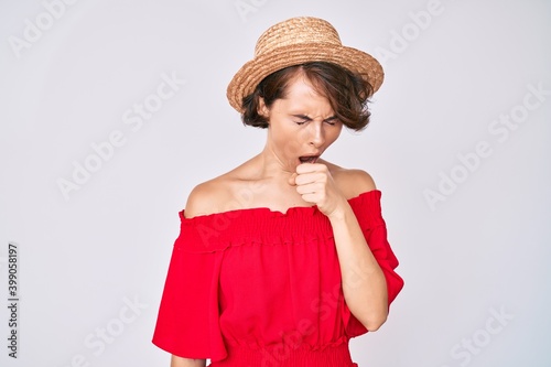 Young hispanic woman wearing summer hat feeling unwell and coughing as symptom for cold or bronchitis. health care concept.