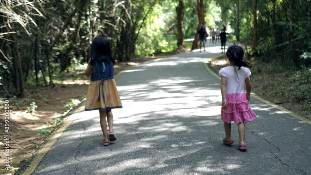 Slow motion scene of 4-5 year old Asian girl walking learning nature path Slow motion scene of 4-5 year old Asian girl walking learning nature path