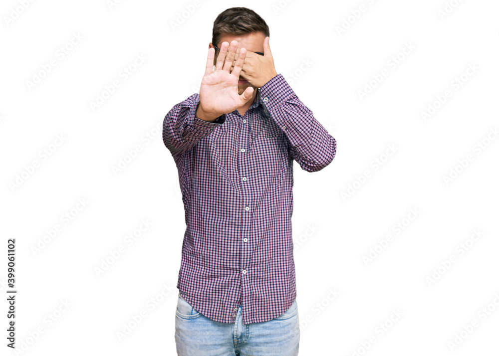 Handsome caucasian man wearing casual clothes and glasses covering eyes with hands and doing stop gesture with sad and fear expression. embarrassed and negative concept. Handsome caucasian man wearing casual clothes and glasses covering eyes with hands and doing stop gesture with sad and fear expression. embarrassed and negative concept.
