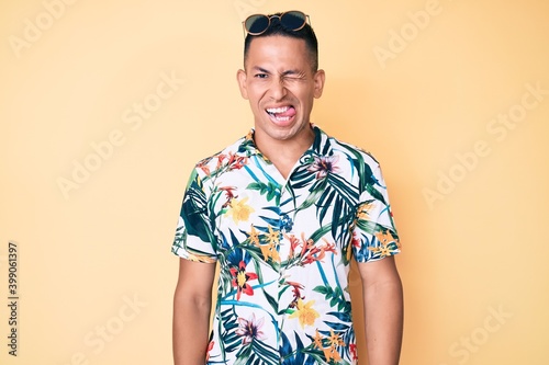 Wallpaper Mural Young handsome latin man wearing summer clothes winking looking at the camera with sexy expression, cheerful and happy face. Torontodigital.ca