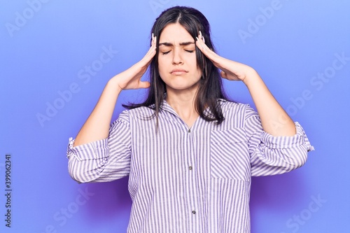 Young beautiful girl wearing casual striped shirt with hand on head, headache because stress. suffering migraine.