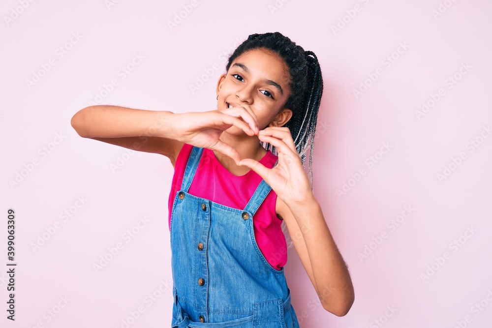 Young african american girl child with braids wearing casual clothes over pink background smiling in love doing heart symbol shape with hands. romantic concept. Young african american girl child with braids wearing casual clothes over pink background smiling in love doing heart symbol shape with hands. romantic concept.