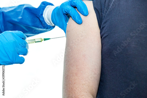 eine   rztin spritzt ein Corona Impfstoff  in einem Krankenhaus