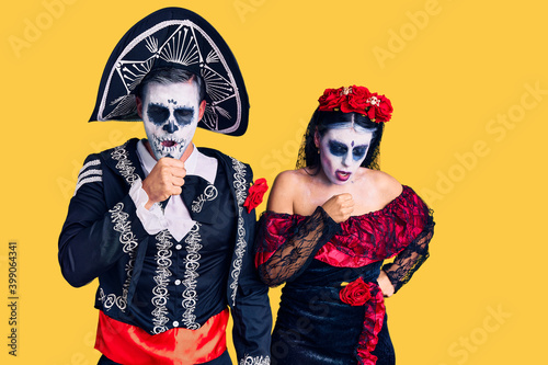 Young couple wearing mexican day of the dead costume over background feeling unwell and coughing as symptom for cold or bronchitis. health care concept.