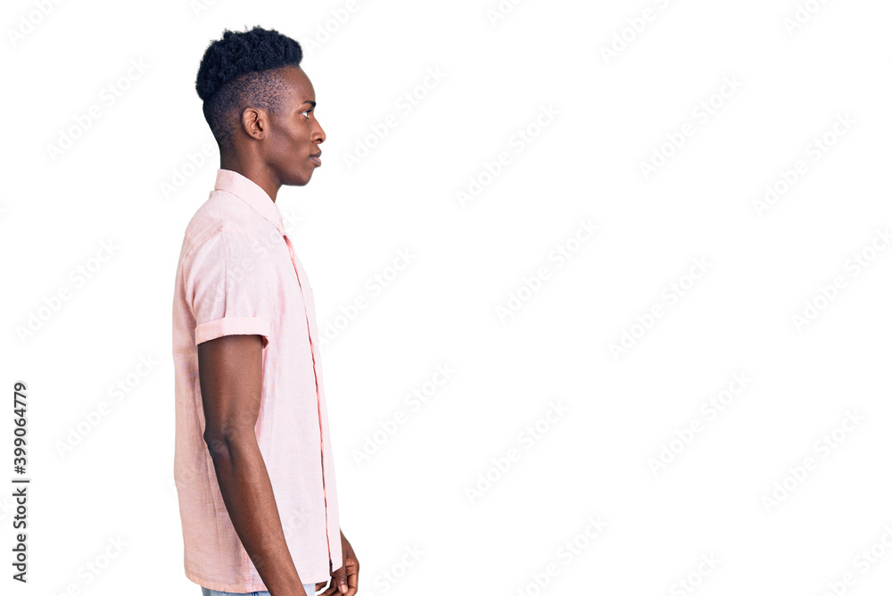 Fototapeta premium Young african american man wearing casual clothes looking to side, relax profile pose with natural face with confident smile.