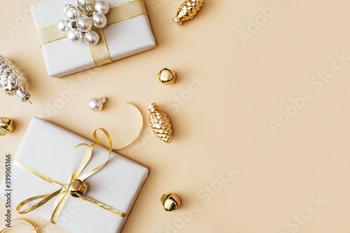 Christmas presents and gifts and gold and silver decorations on beige background. Merry christmas, New Year holiday concept. Flat lay, top view, copy space.