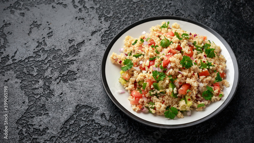 Tabbouleh salad with tomato, cucumber, red onion, bulgur and parsley. Healthy vegan food photo