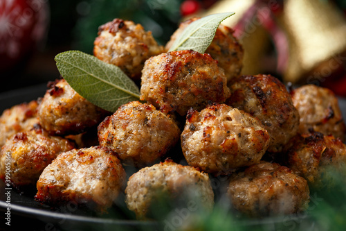 Christmas Pork stuffing meatballs with sage and onion. decoration, gifts, green tree branch on wooden rustic table photo