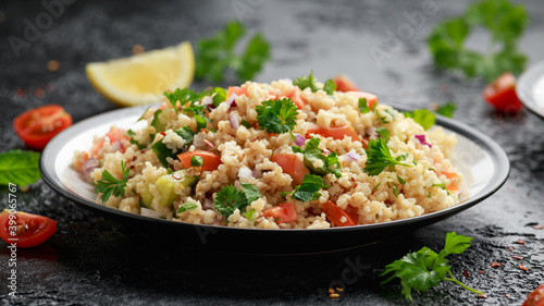 Tabbouleh salad with tomato, cucumber, red onion, bulgur and parsley. Healthy vegan food photo