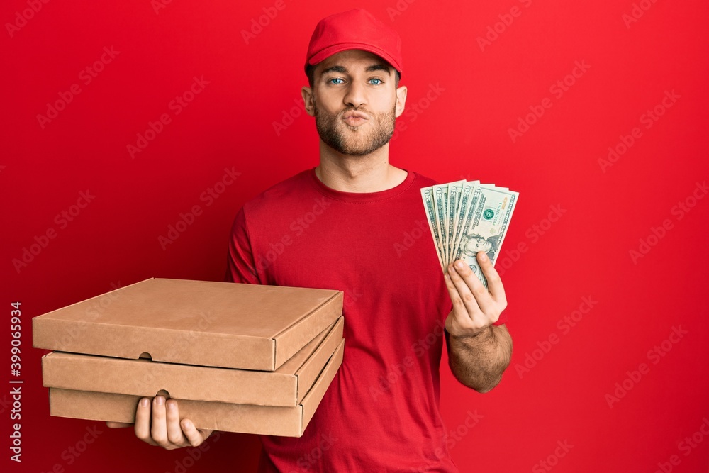 Young caucasian man holding take away food and 20 dollars looking at the camera blowing a kiss being lovely and sexy. love expression. Young caucasian man holding take away food and 20 dollars looking at the camera blowing a kiss being lovely and sexy. love expression.