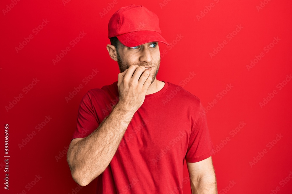 Young caucasian man wearing delivery uniform and cap looking stressed and nervous with hands on mouth biting nails. anxiety problem. Young caucasian man wearing delivery uniform and cap looking stressed and nervous with hands on mouth biting nails. anxiety problem.
