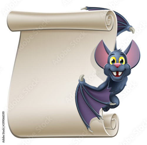 A cute Halloween vampire bat animal cartoon character peeking around from behind a scroll banner sign and pointing at it with their wing photo