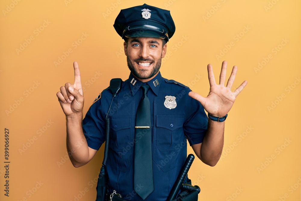 Handsome hispanic man wearing police uniform showing and pointing up with fingers number six while smiling confident and happy. Handsome hispanic man wearing police uniform showing and pointing up with fingers number six while smiling confident and happy.