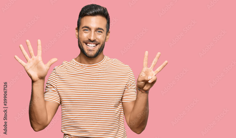 Handsome hispanic man wearing casual clothes showing and pointing up with fingers number eight while smiling confident and happy.