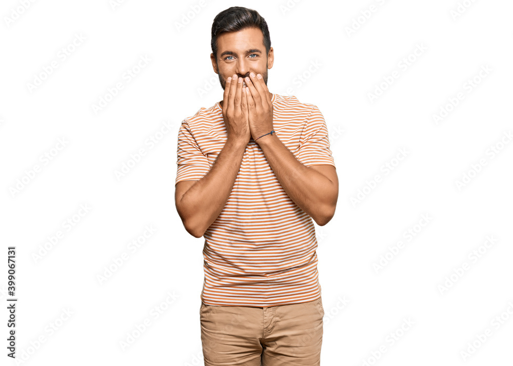 Handsome hispanic man wearing casual clothes laughing and embarrassed giggle covering mouth with hands, gossip and scandal concept Handsome hispanic man wearing casual clothes laughing and embarrassed giggle covering mouth with hands, gossip and scandal concept