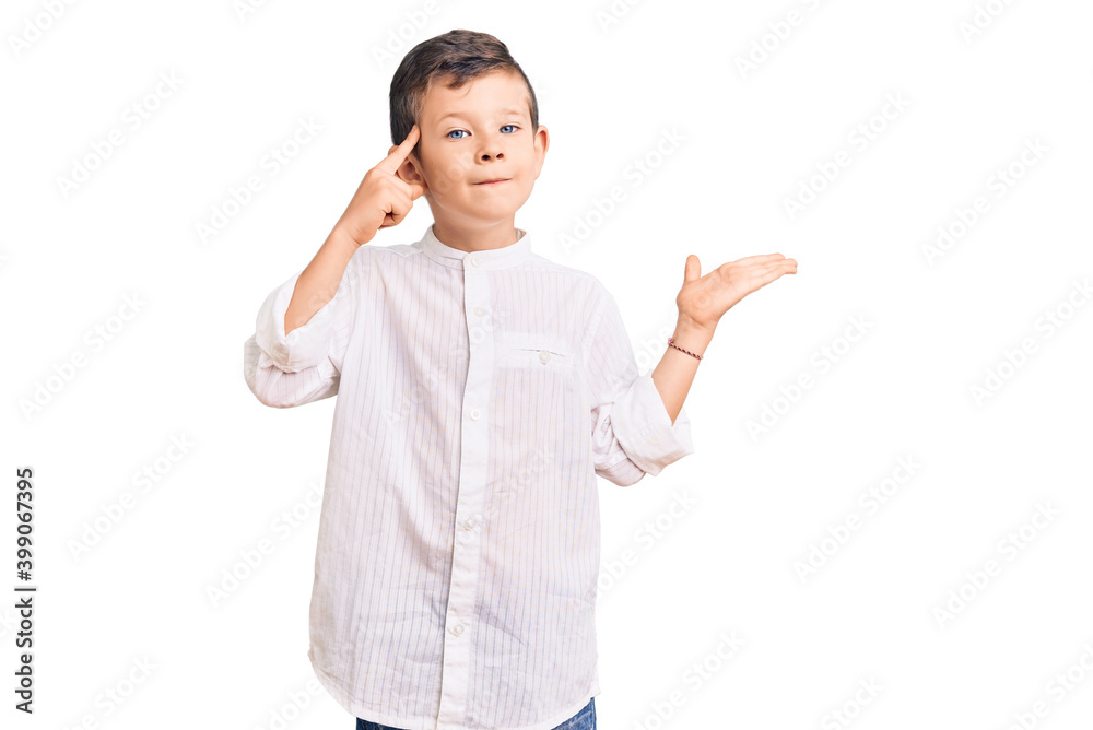 Cute blond kid wearing elegant shirt confused and annoyed with open palm showing copy space and pointing finger to forehead. think about it. Cute blond kid wearing elegant shirt confused and annoyed with open palm showing copy space and pointing finger to forehead. think about it.