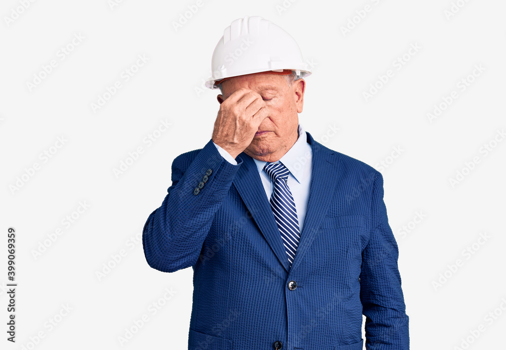 Senior handsome grey-haired man wearing suit and architect hardhat tired rubbing nose and eyes feeling fatigue and headache. stress and frustration concept. Senior handsome grey-haired man wearing suit and architect hardhat tired rubbing nose and eyes feeling fatigue and headache. stress and frustration concept.