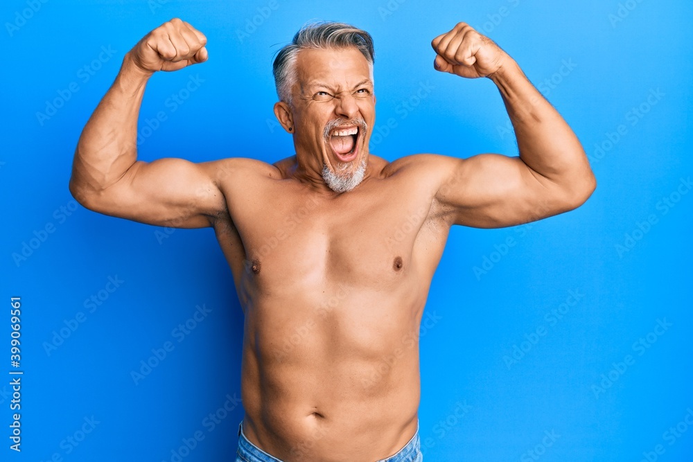 Middle age grey-haired man standing shirtless doing fitness gesture angry and mad screaming frustrated and furious, shouting with anger. rage and aggressive concept.