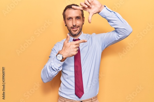 Young handsome man wearing business clothes smiling making frame with hands and fingers with happy face. creativity and photography concept.