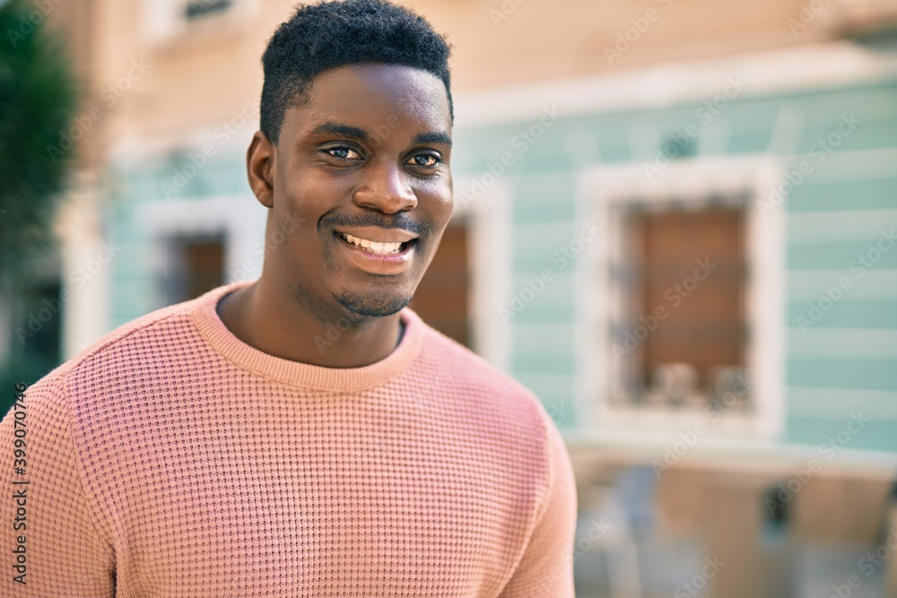 Young african american man smiling happy standing at the city.