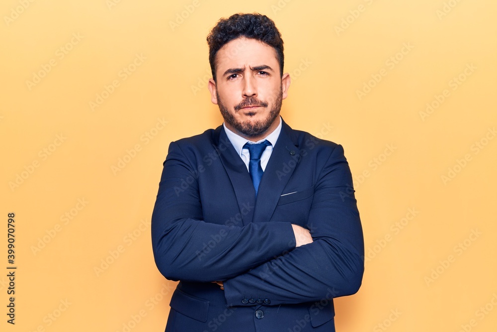 Young hispanic man wearing suit skeptic and nervous, disapproving expression on face with crossed arms. negative person. Young hispanic man wearing suit skeptic and nervous, disapproving expression on face with crossed arms. negative person.