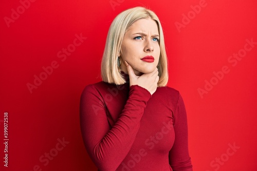 Young blonde woman wearing casual clothes touching painful neck, sore throat for flu, clod and infection
