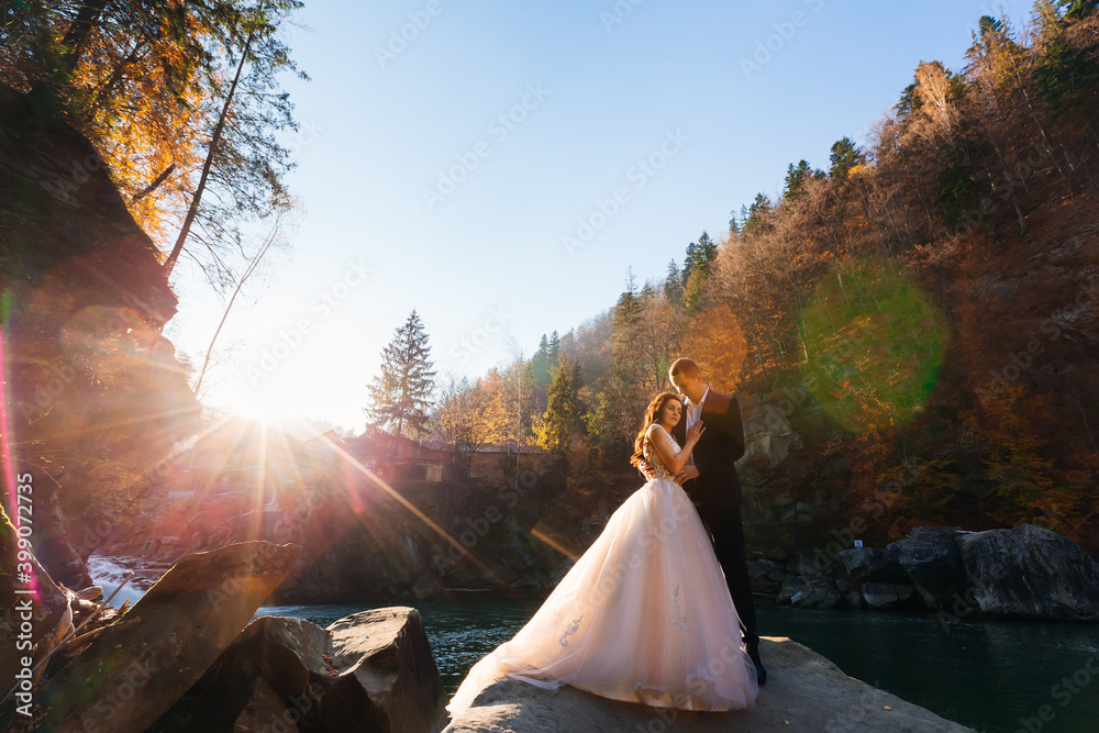 autumn in the mountains. the newlyweds are hugging and standing