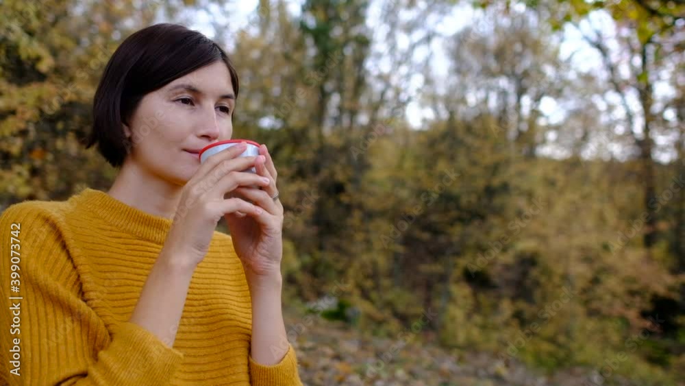 Pretty young woman with hot tasty drink spending vacations among autumn forest. Pretty young woman with hot tasty drink spending vacations among autumn forest.