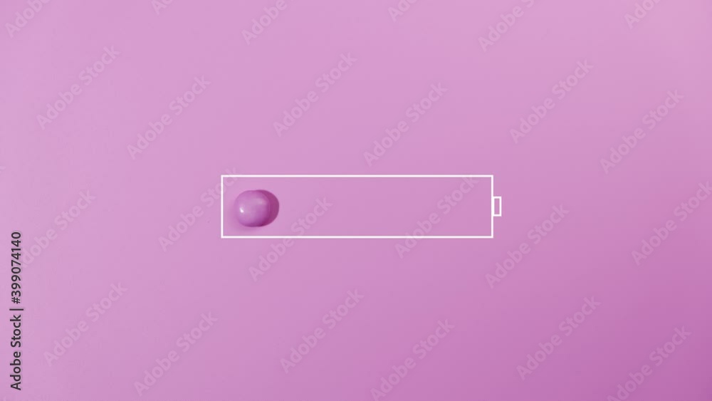 Charging battery indicator of sweet candies on pink background.
