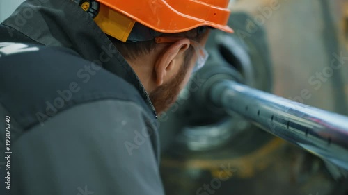 This video shows a close-up of a mechanic observing the undercarriage reboring procedure. Rear view. photo