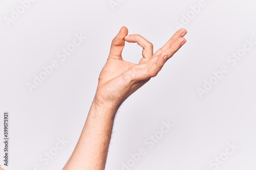 Close up of hand of young caucasian man over isolated background gesturing approval expression doing okay symbol with fingers