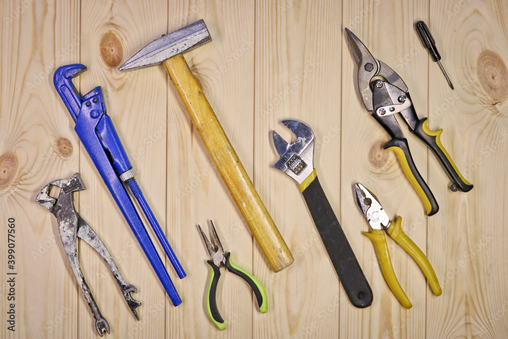 A set of assorted work carpentry and locksmith tools on a light wooden background with copy space. A set of assorted work carpentry and locksmith tools on a light wooden background with copy space.