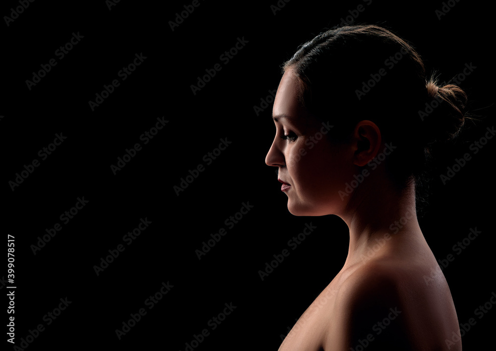 Fototapeta premium young girl posing in backlight on a black background