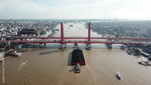 Coal barge crosses the Musi river on the Ampera bridge