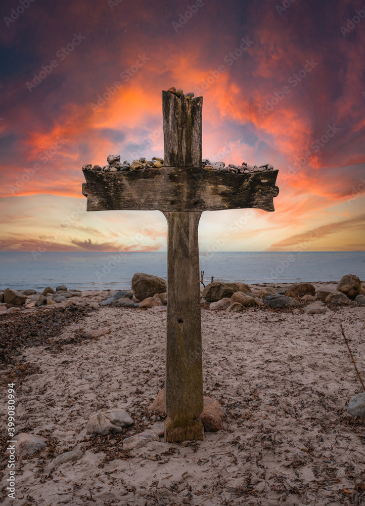 Big wooden cross at the seaside while coloful sunset Big wooden cross at the seaside while coloful sunset